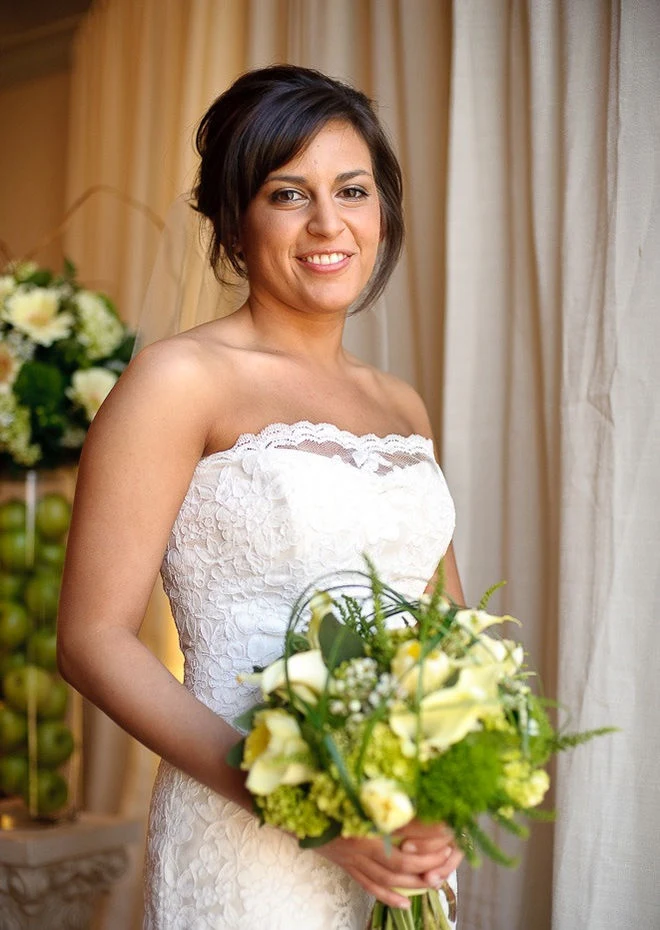 A smiling bride holding her wedding bouquet