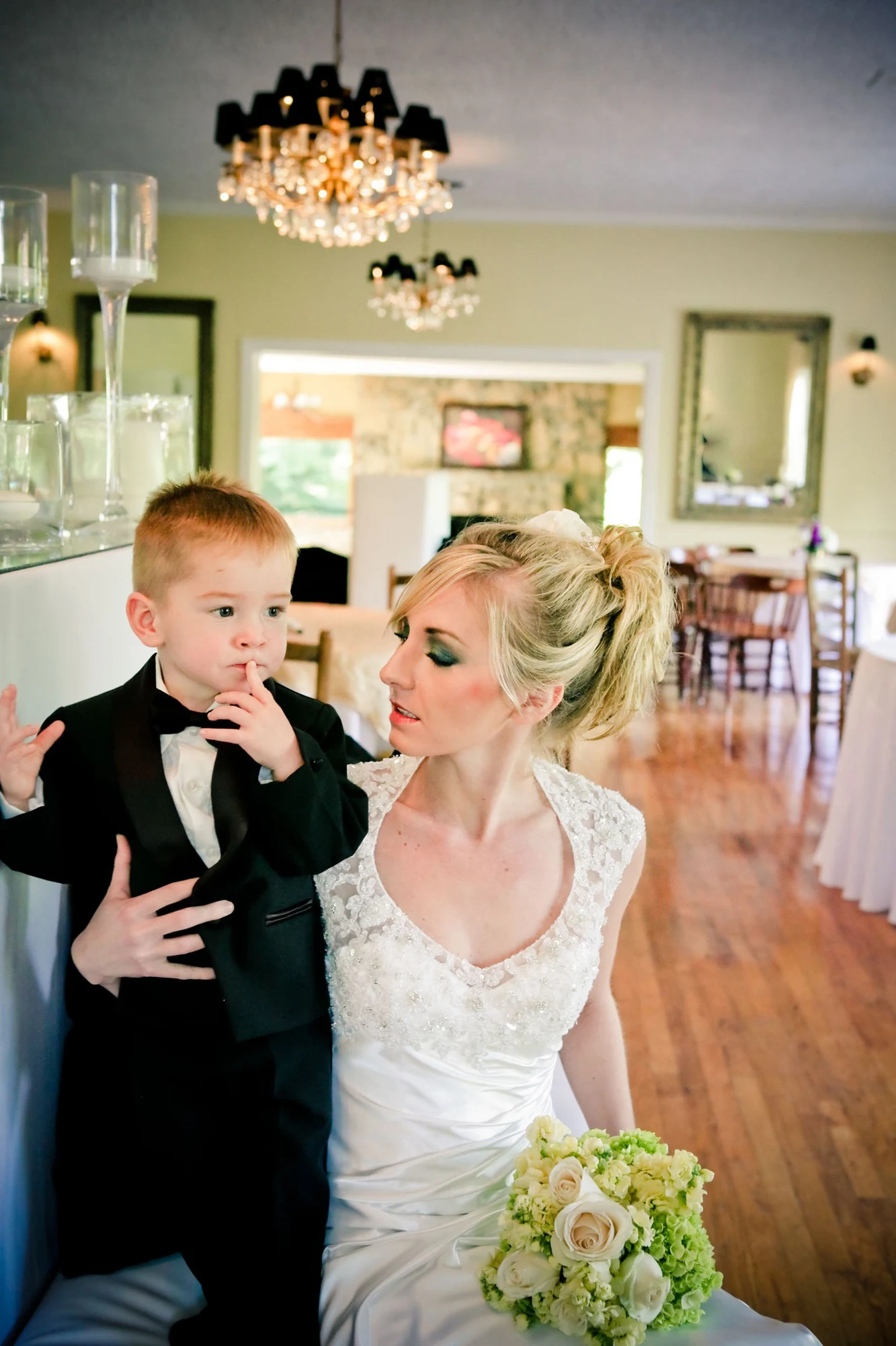 A bride sharing a quiet moment with a young attendant